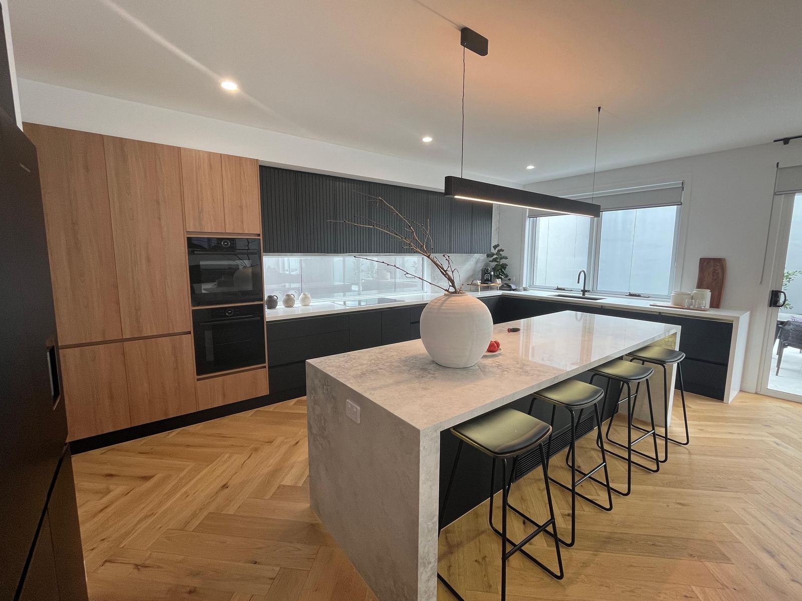 Modern timber-veneer kitchen with island bench manufactured by Oktay Cabinets