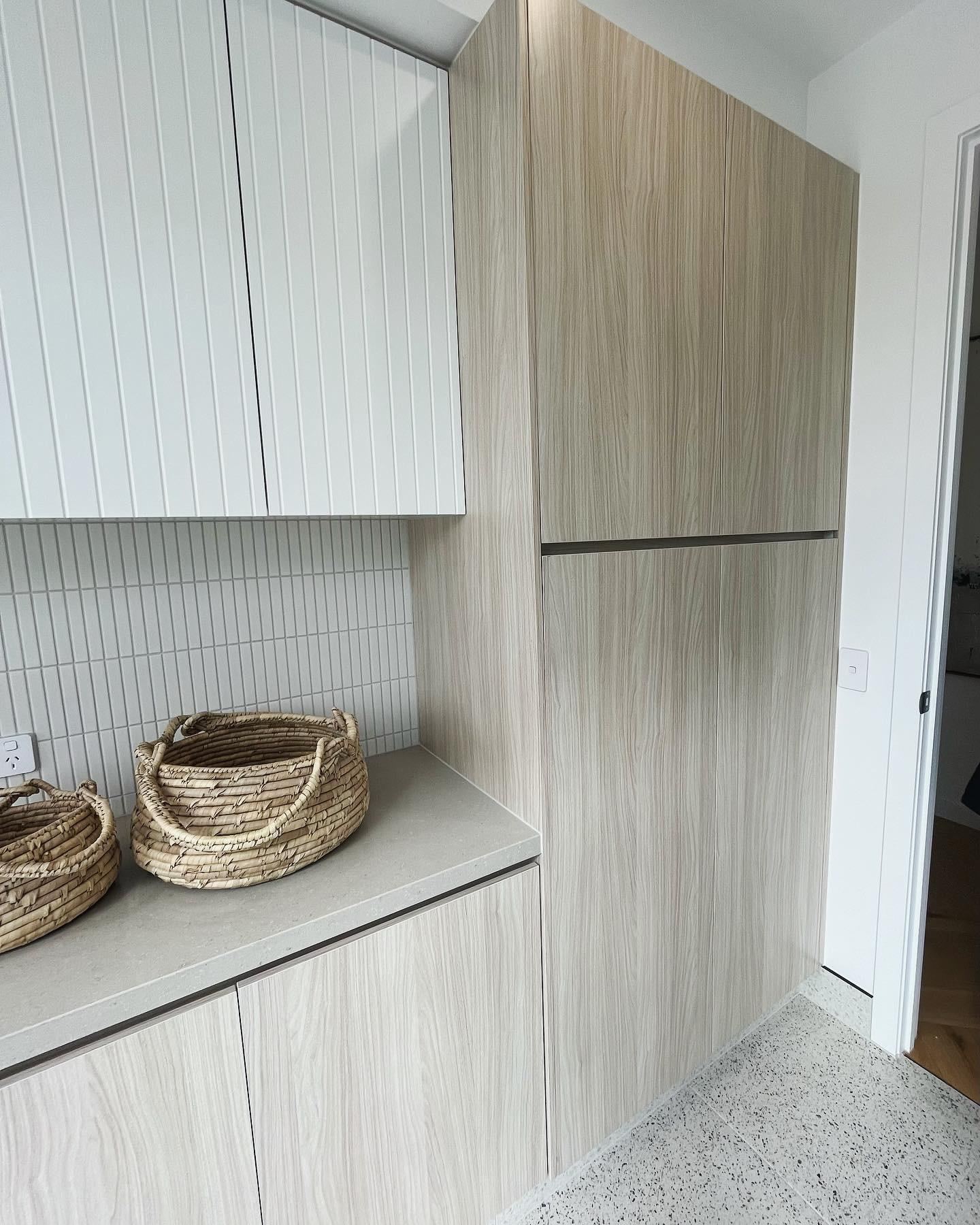 Tall timber-toned storage cabinetry with styled vignette